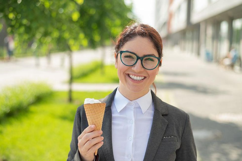 Woman eats ice cream at work during the summer