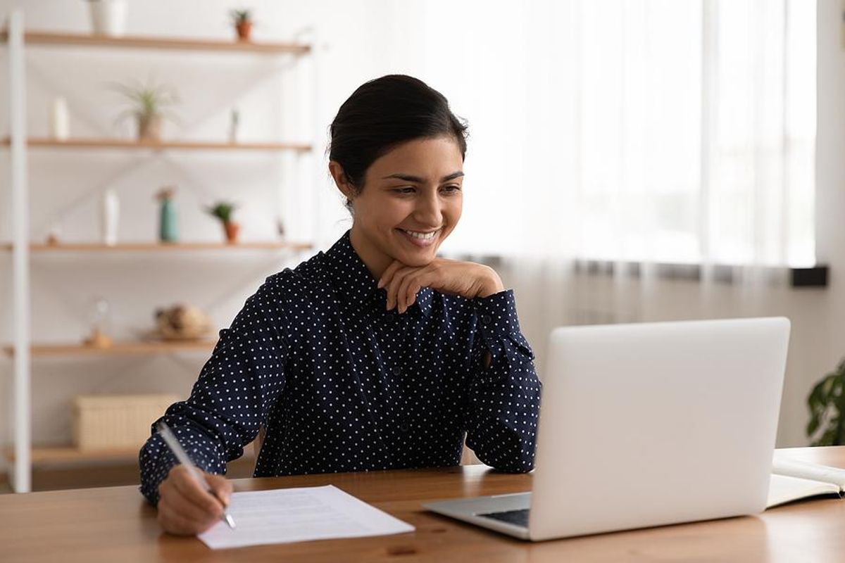 Woman edits her resume while looking for a job on her laptop
