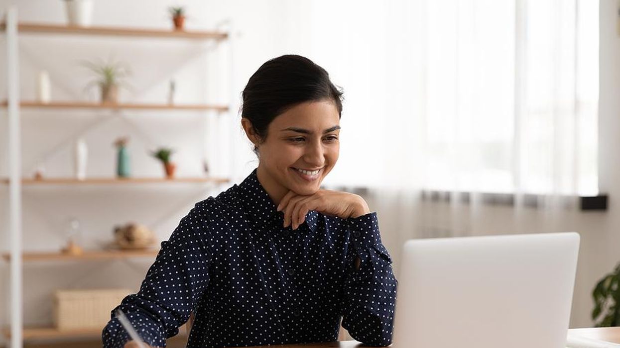 Woman edits her resume while looking for a job on her laptop