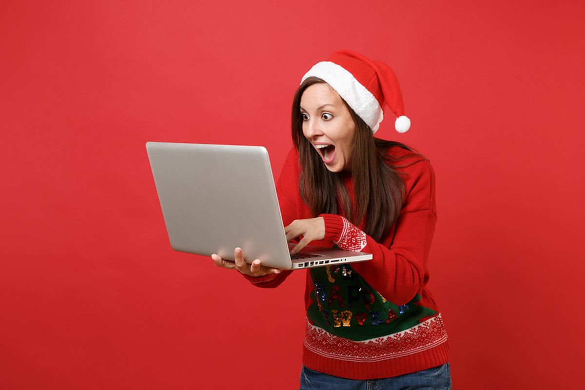 Woman holding laptop continues her job search through the holiday season