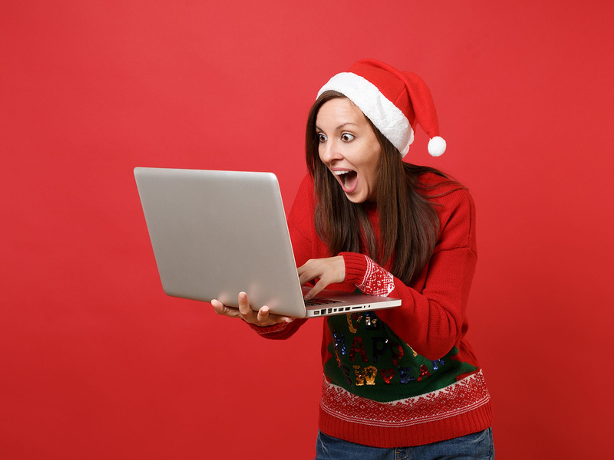 Woman holding laptop continues her job search through the holiday season