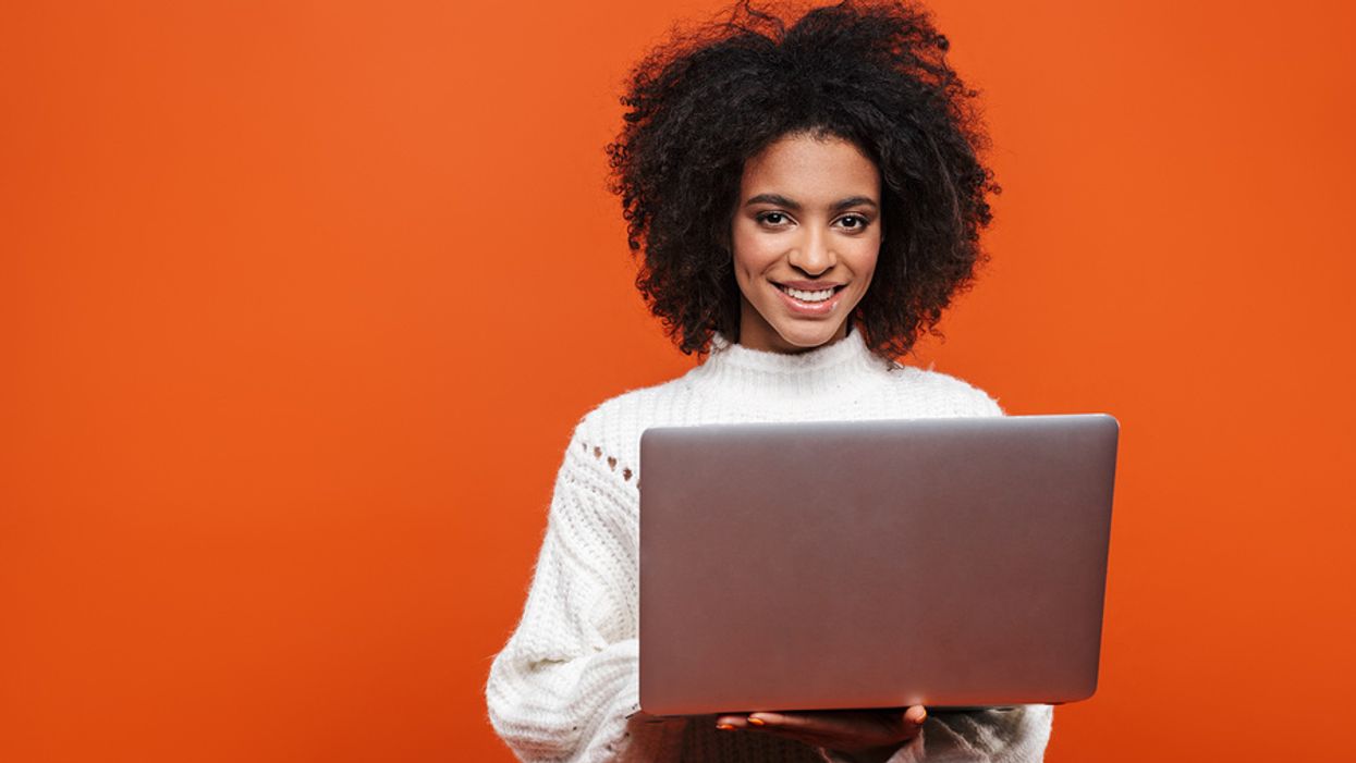 Woman holding laptop gets her resume past the ATS