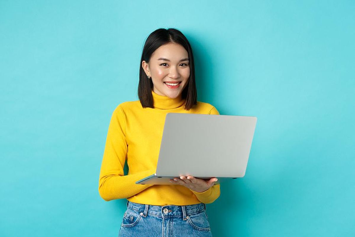 Woman holding laptop happy in her career