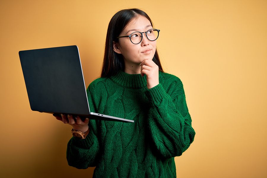 Woman holding laptop wondering how she should format her resume