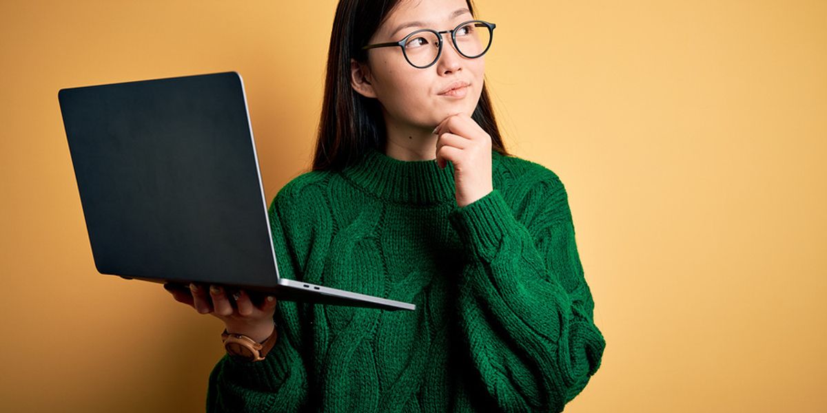 woman holding laptop wondering how she should format her resume