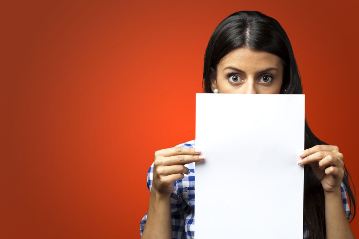 Woman holds up her resume free of the common resume mistakes every job seeker should avoid