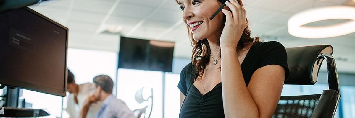 Woman in call center talks to a customer on the phone