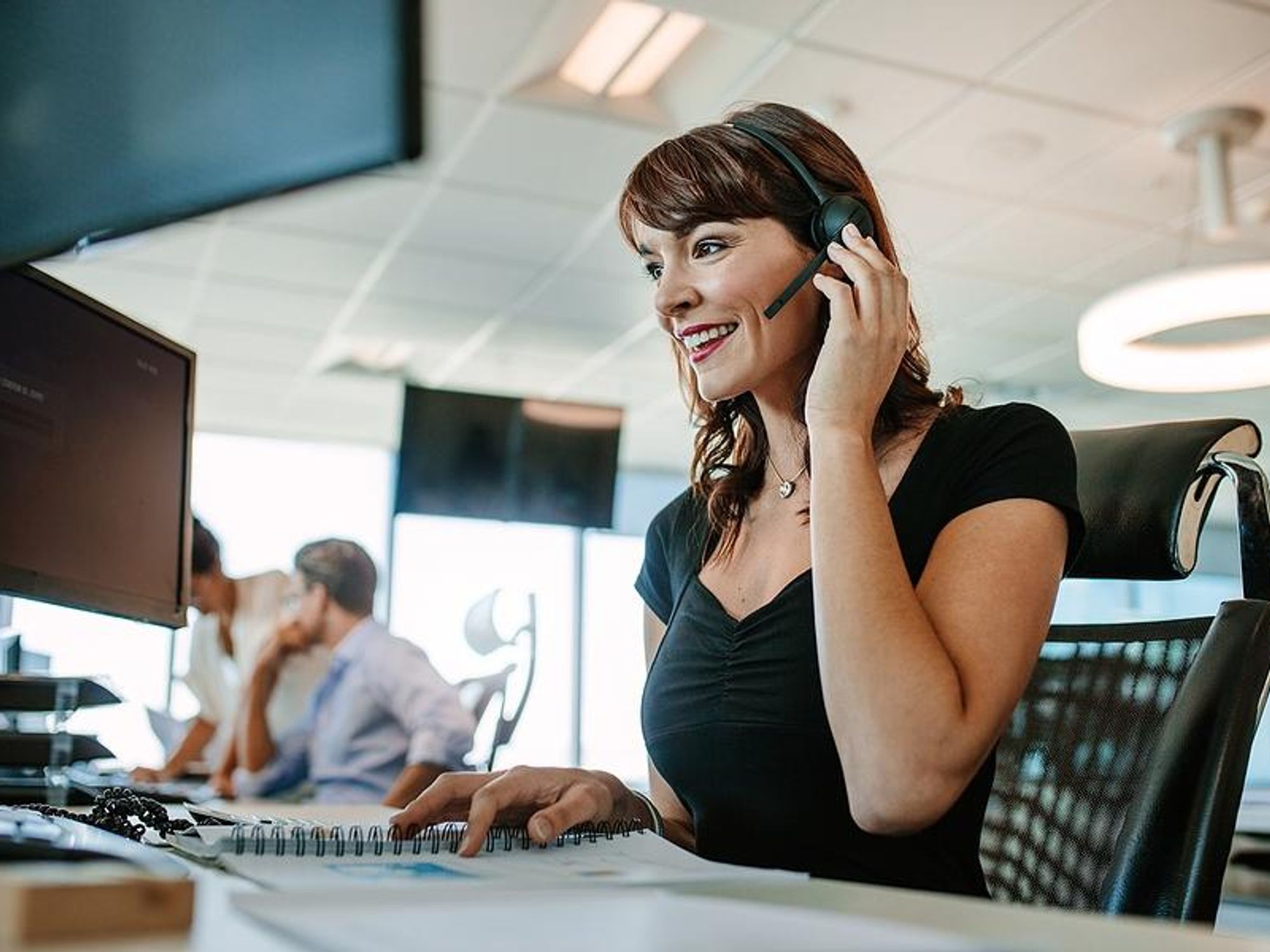 Woman in call center talks to a customer on the phone
