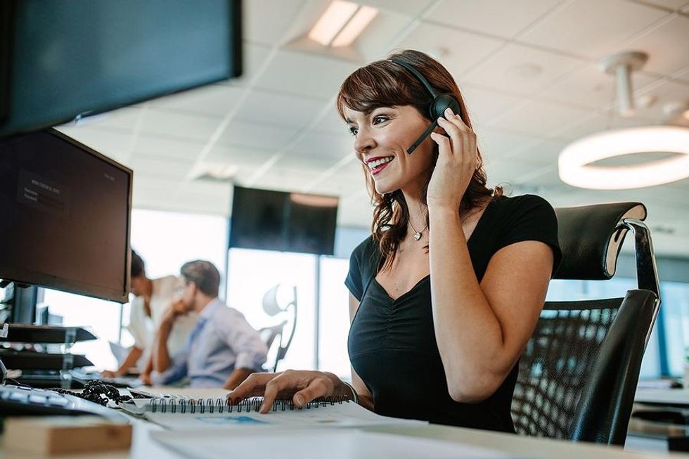 Woman in call center talks to a customer on the phone