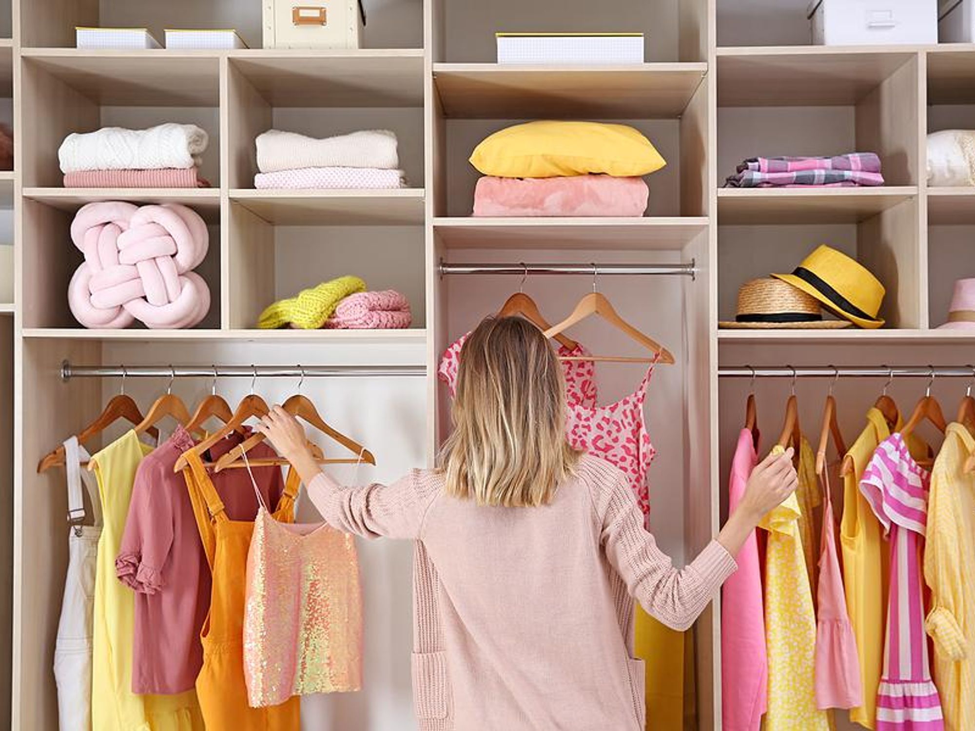 Woman looks at clothes in her wardrobe/closet