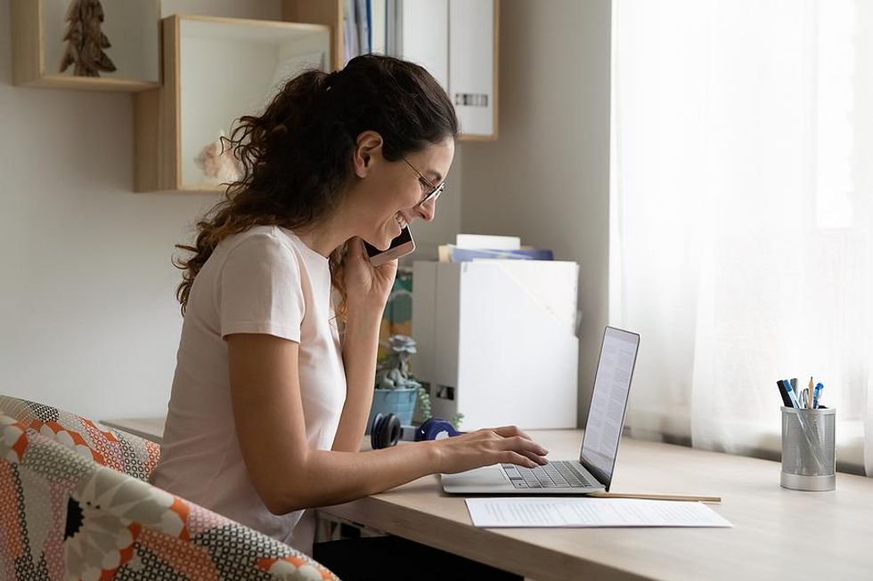 Woman looks at laptop during a phone interview