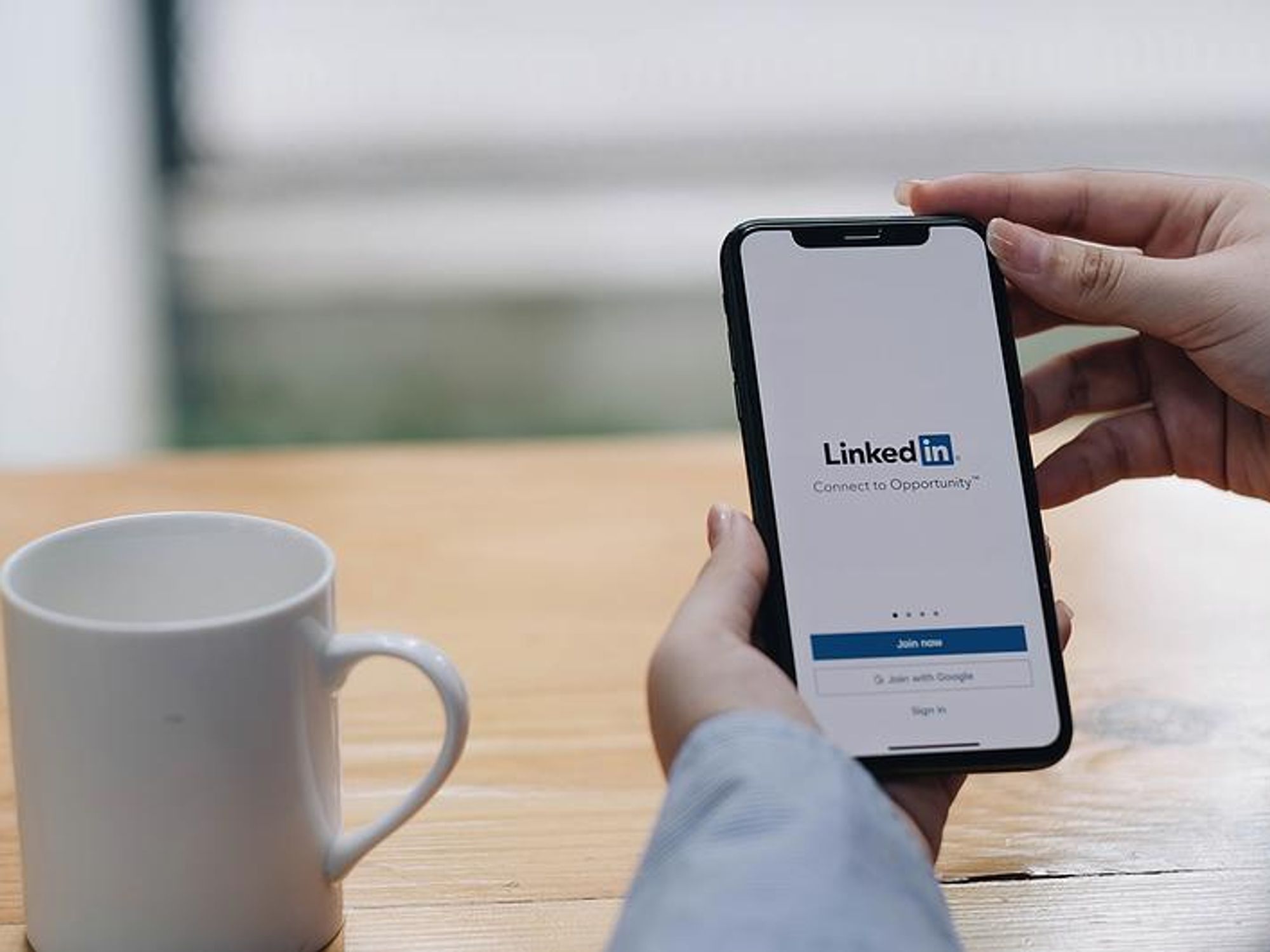 Woman looks at LinkedIn on her phone