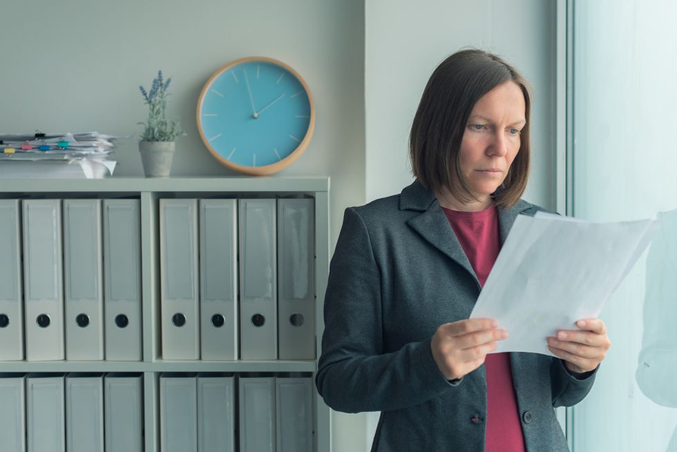 Woman looks at list of people she needs to lay off