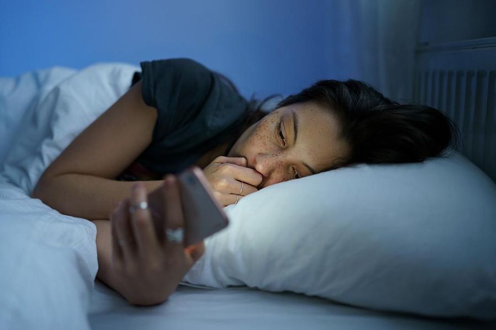 Woman looks at social media before bed