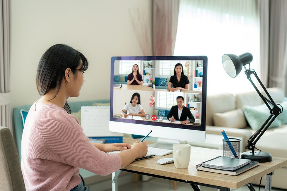 Woman on a video call takes notes to be a better employee and earn a raise