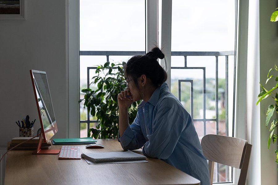 Woman on computer thinks about taking a lower-level position