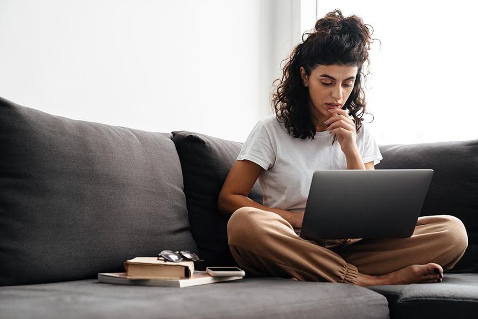 Woman on laptop applies to jobs through a staffing agency