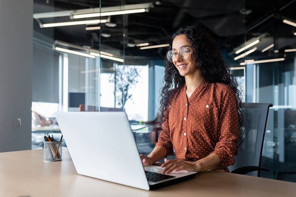 Woman on laptop at work avoids getting laid off