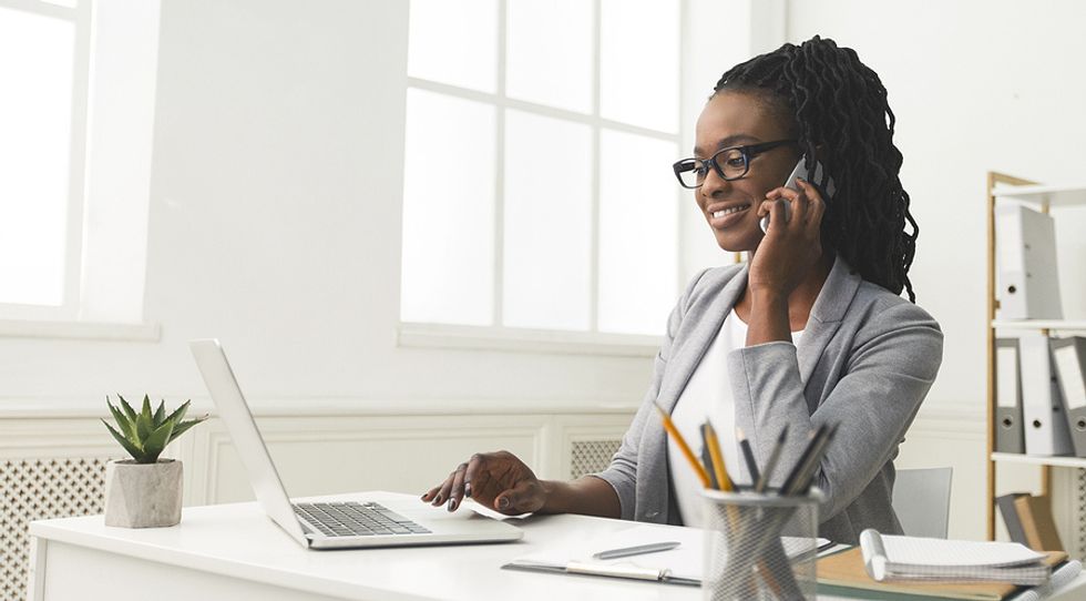 Woman on laptop attends a phone screen interview