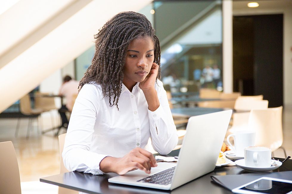 Woman on laptop considers quitting her job