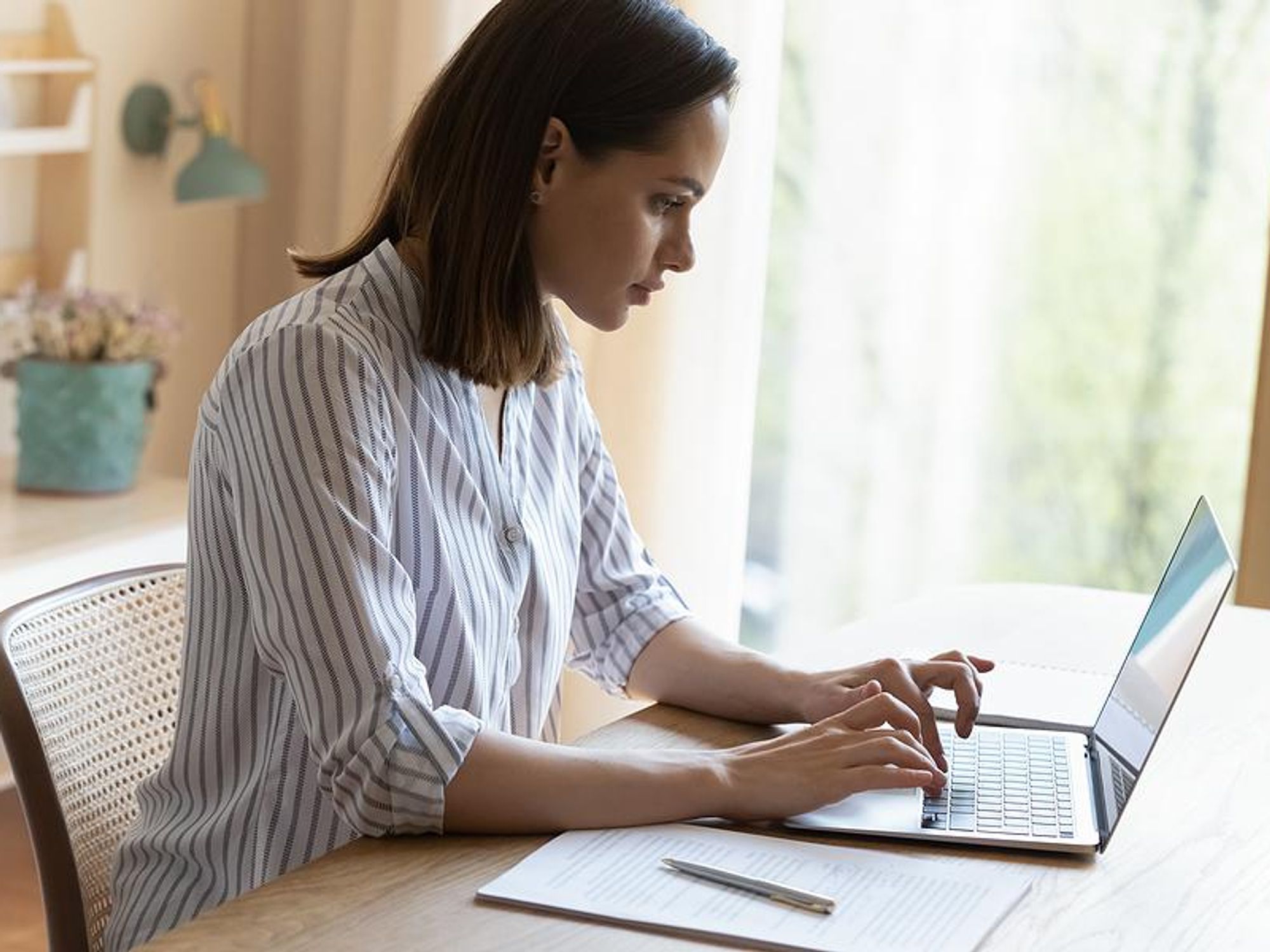 Woman on laptop emails her cover letter to an employer