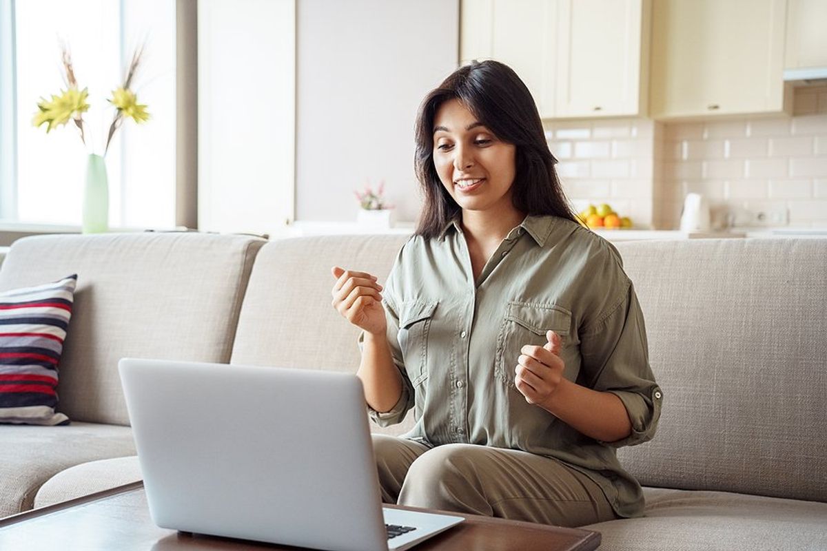 Woman on laptop for a virtual interview tells the hiring manager a few stories