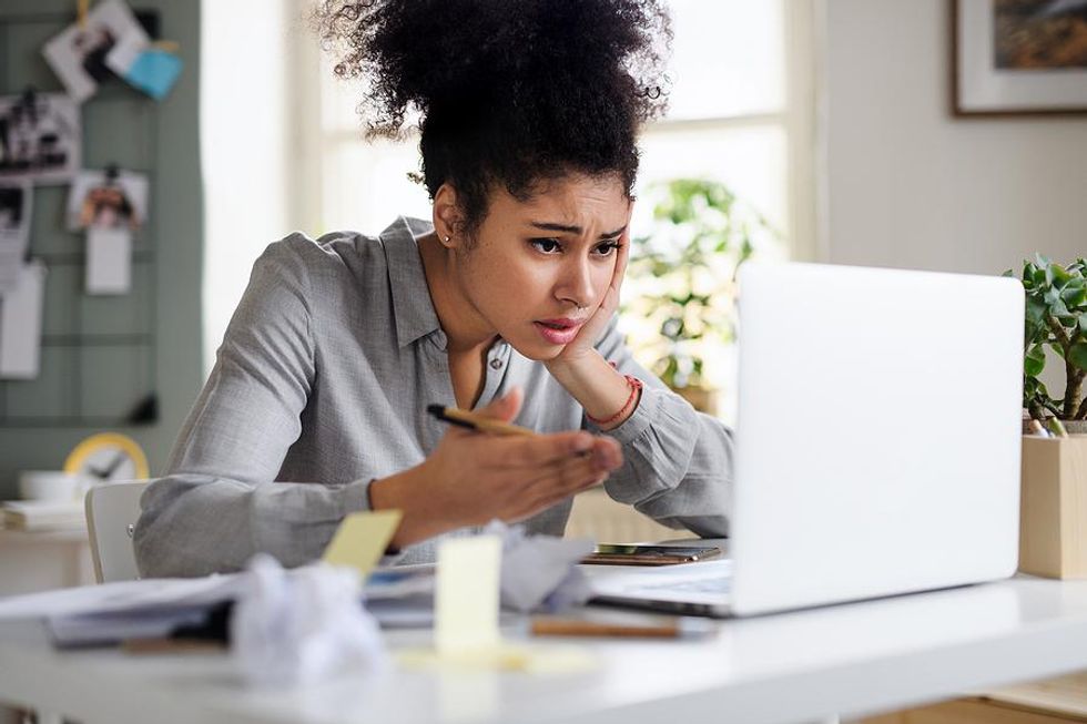 Woman on laptop frustrated at work