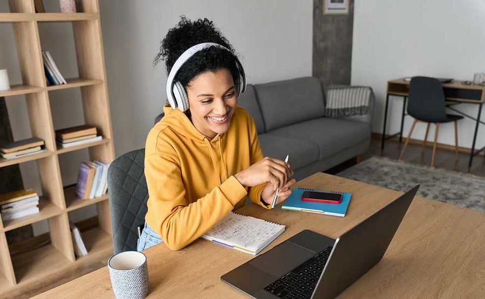 Woman on laptop joins an online community event for accountability