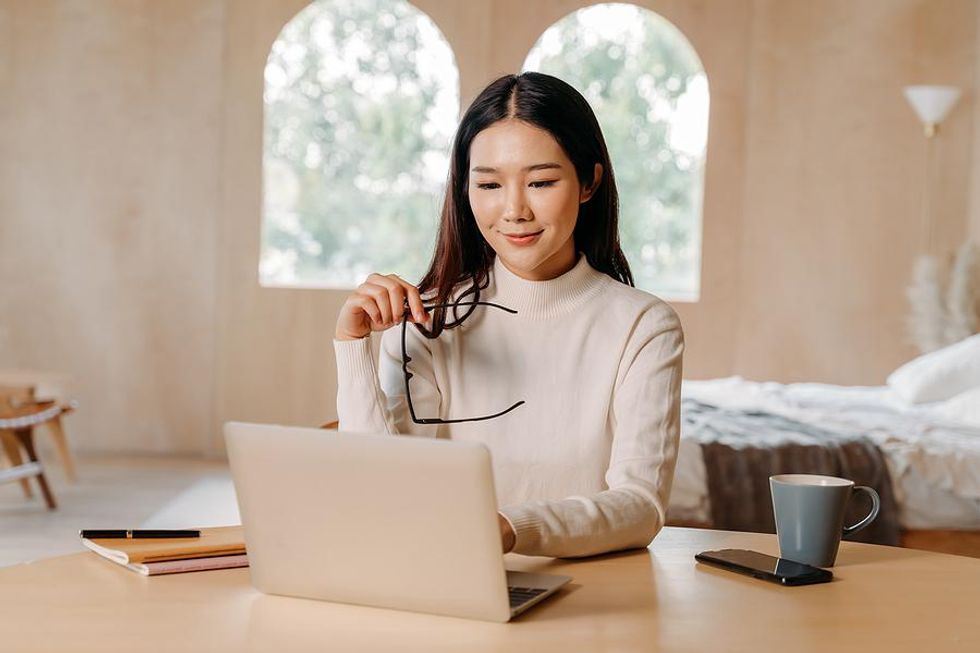 Woman on laptop leverages her network during a proactive job search