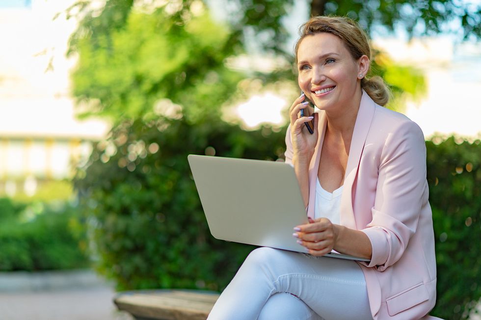 Woman on laptop looks for a job after being laid off