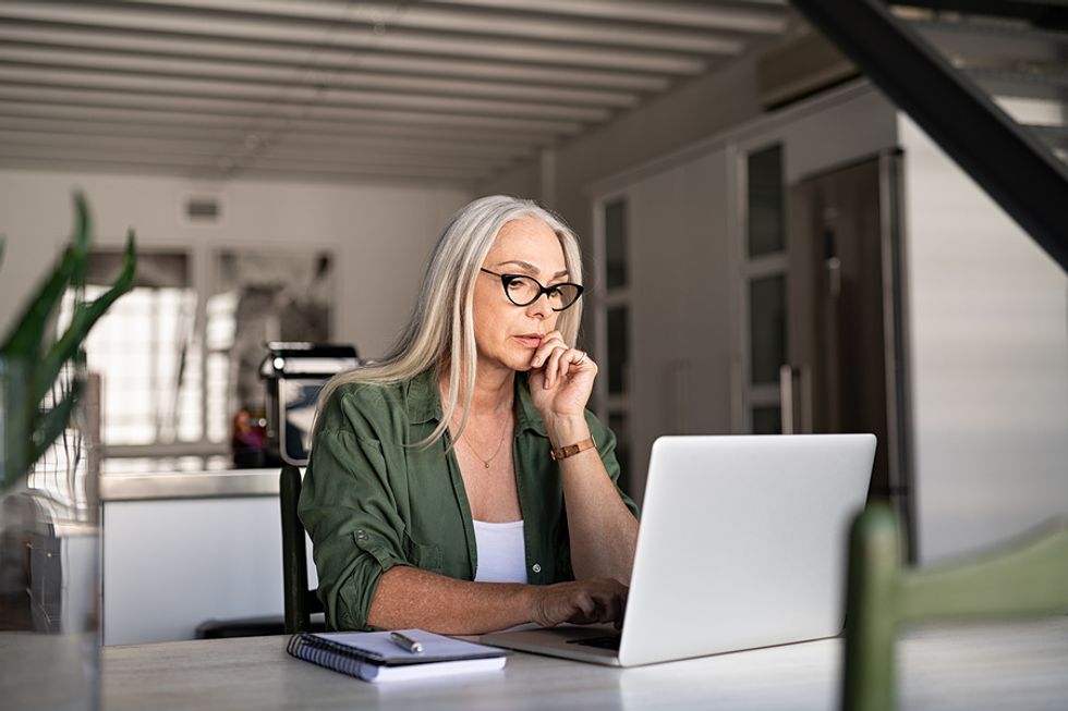 Woman on laptop looks for a job during a recession