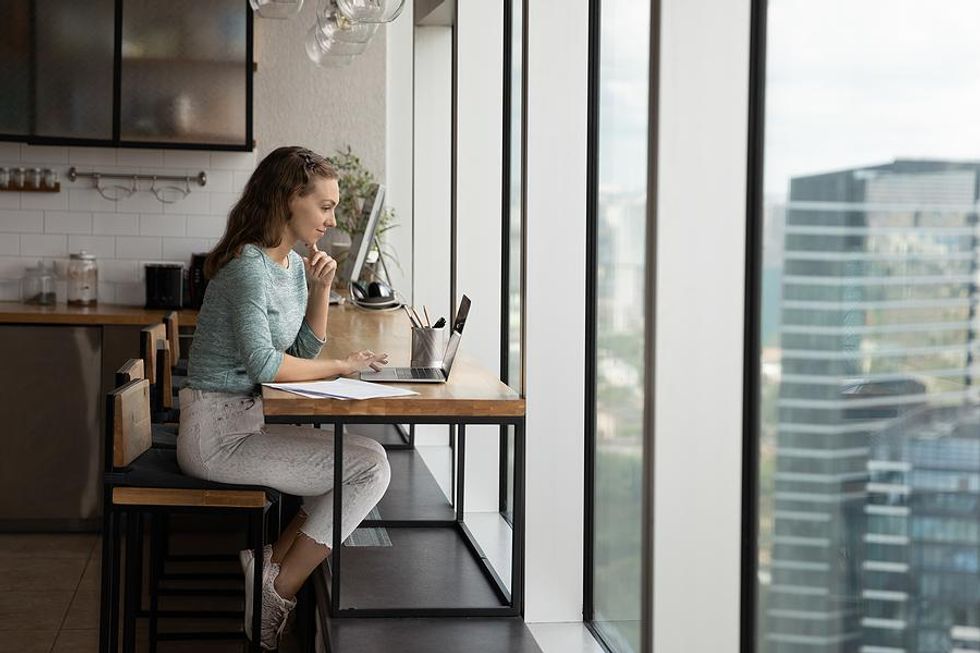 Woman on laptop posts discussions in LinkedIn groups