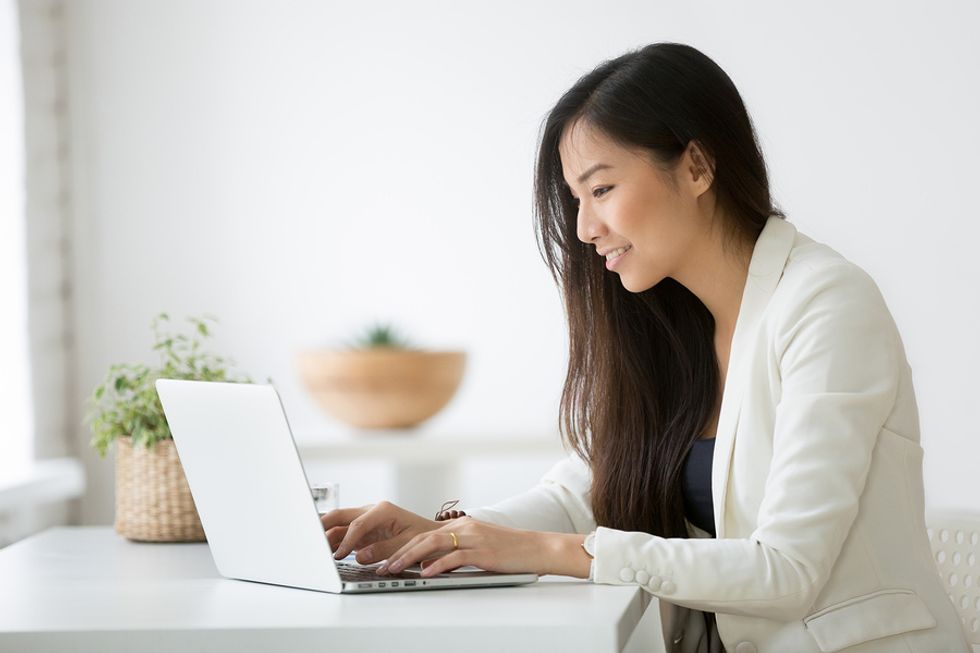 Woman on laptop research companies that will be attending a job fair