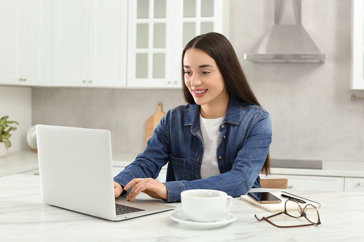 Woman on laptop researches cover letter trends before writing her disruptive cover letter
