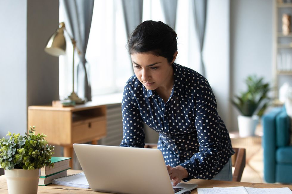 Woman on laptop researches the types of unemployment insurance fraud