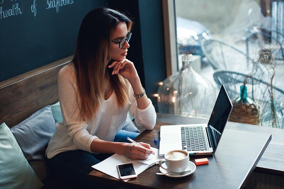 Woman on laptop rewrites her resume