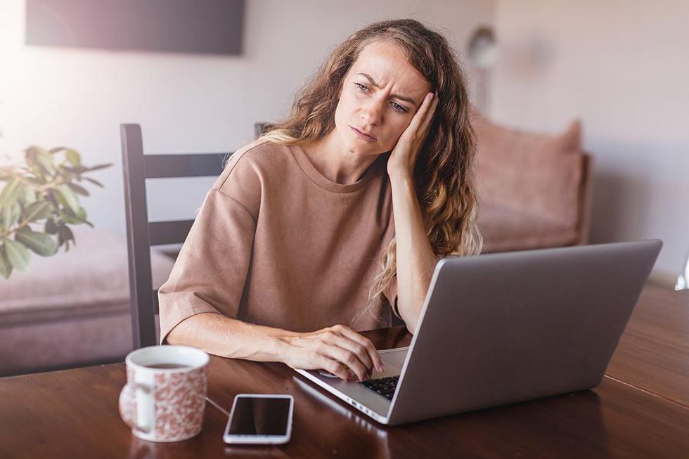 Woman on laptop scared to find a new job