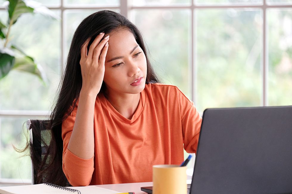 Mujer estresada en la computadora portátil porque mintió en su currículum