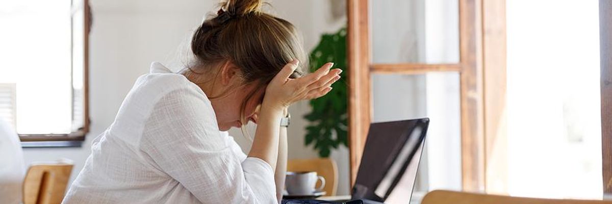 Woman on laptop stressed and frustrated about her job search