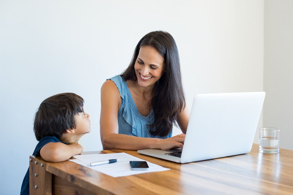 Woman on laptop talks to her son while working from home