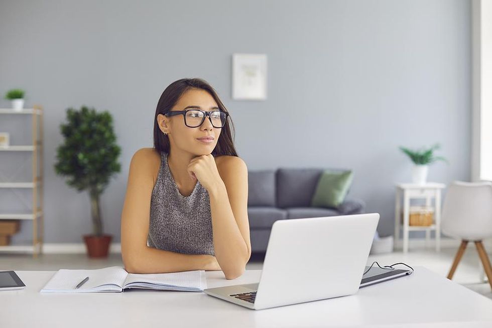 Woman on laptop thinks about messaging a LinkedIn connection