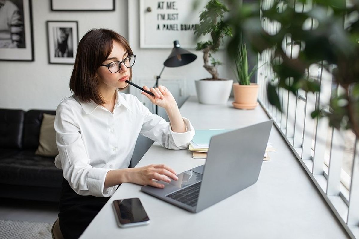 Woman on laptop thinks about whether she should add a short-term job to her resume