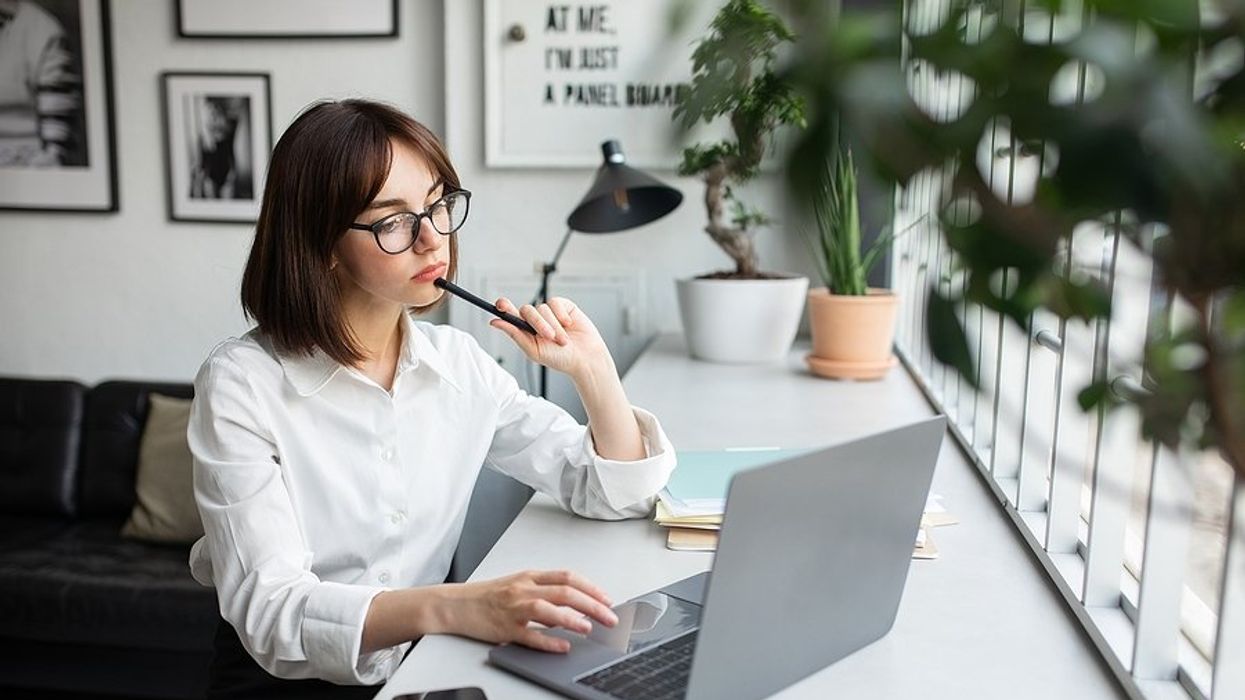 Woman on laptop thinks about whether she should add a short-term job to her resume