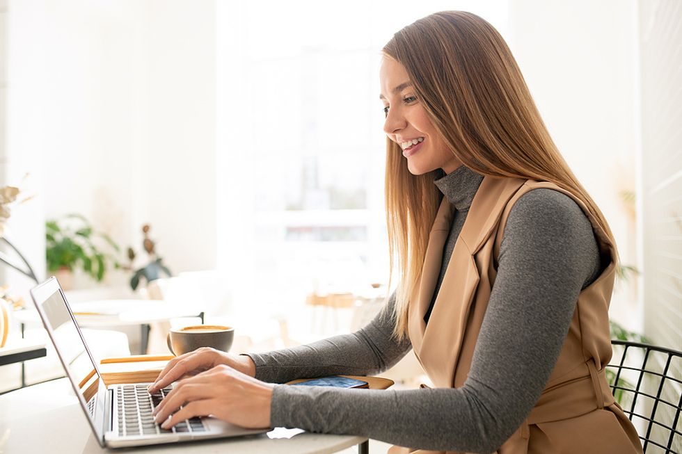 Woman on laptop uses powerful words on her resume