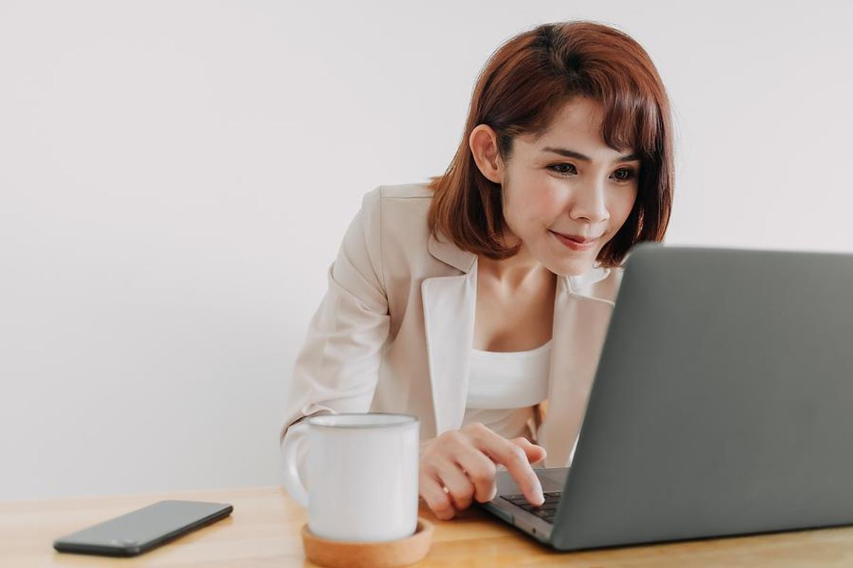 Woman on laptop writes a LinkedIn invitation