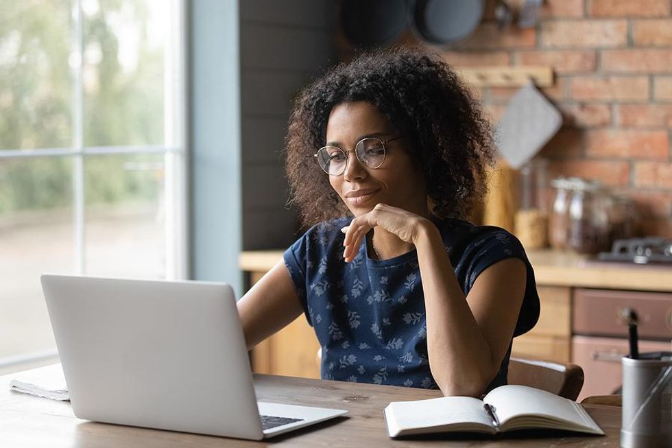 Woman on laptop writes a resume after being fired