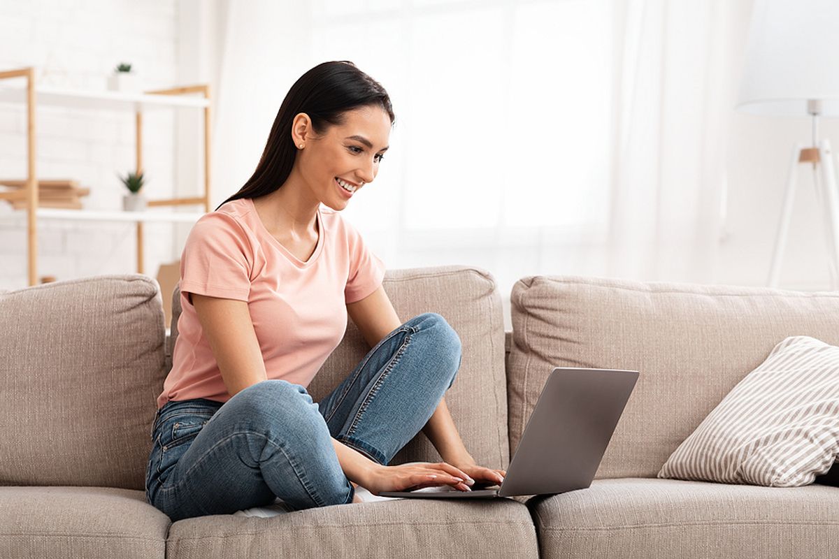Woman on laptop writes her LinkedIn profile while unemployed