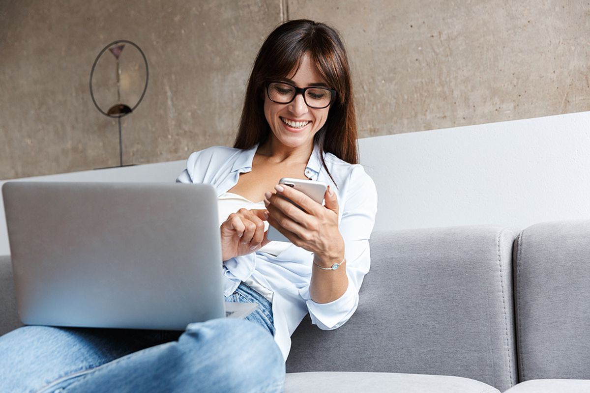 Woman on phone and laptop takes advantage of being unemployed