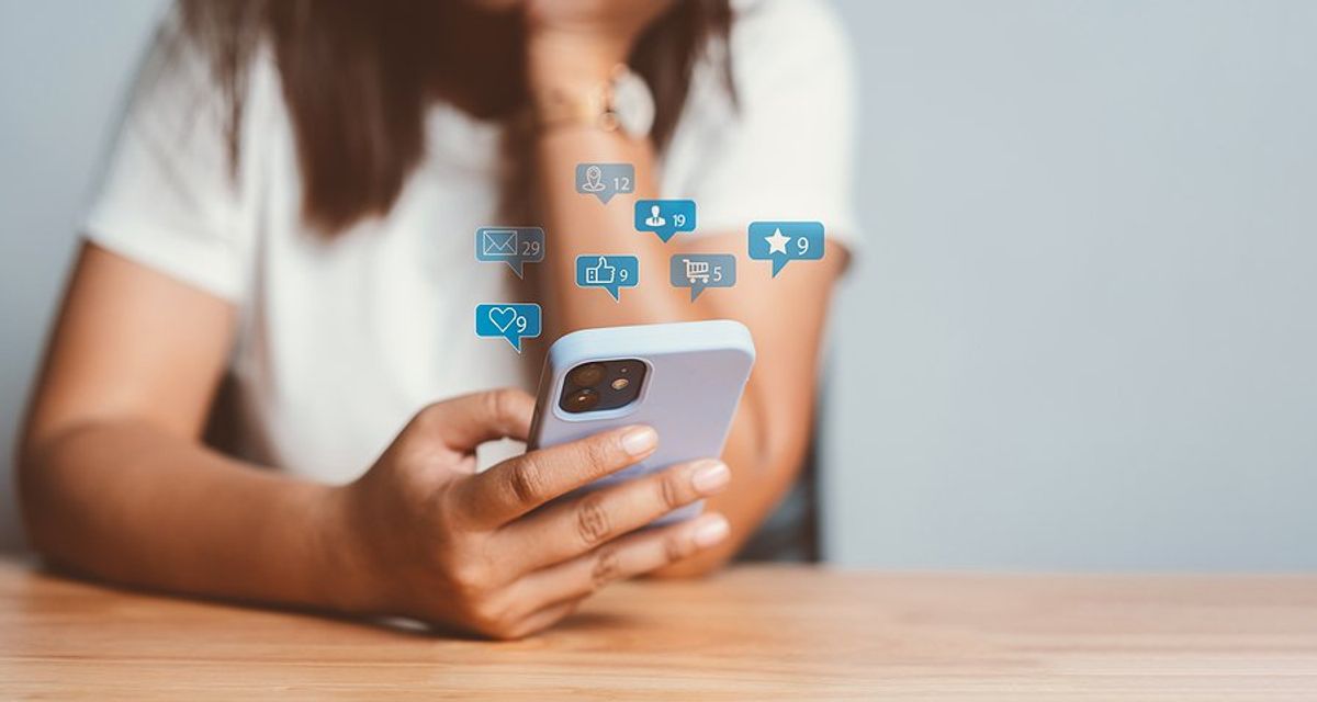 Woman on phone uses social media to post online content to generate sales