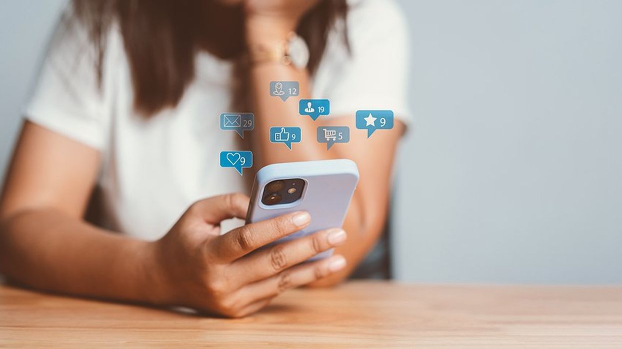 Woman on phone uses social media to post online content to generate sales